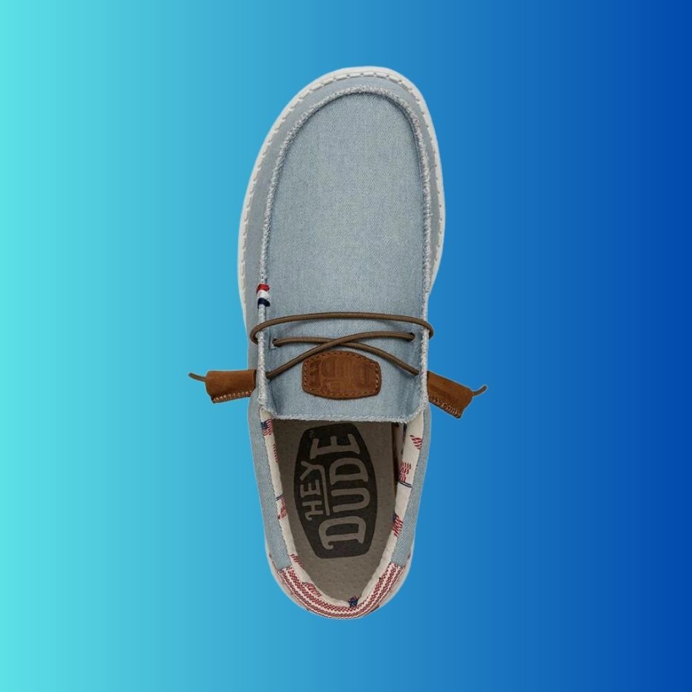 Top view of Hey Dude Wally Americana shoe in Denimi Strip (light blue) with Brown Laces and Hey Dude Logo on tongue.