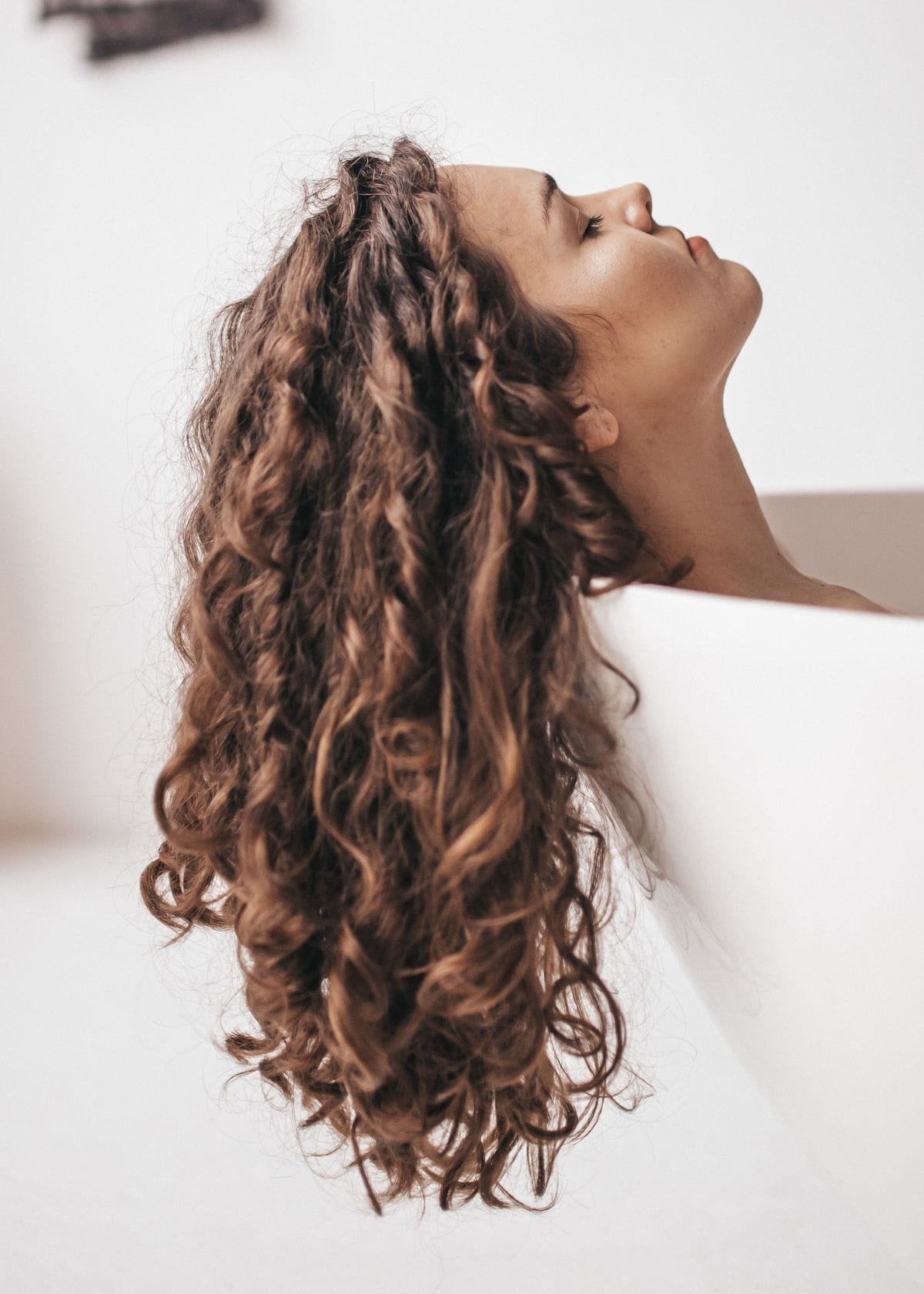 Woman in bath with long, curly hair